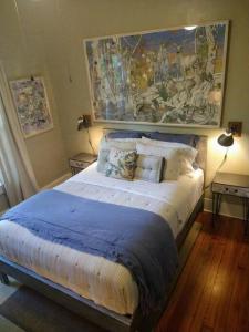 a bedroom with a large bed with a painting on the wall at Gingerbird Art Suite in Laurel
