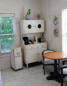 une chambre avec une table, une armoire et une table dans l'établissement Gingerbird Art Suite, à Laurel