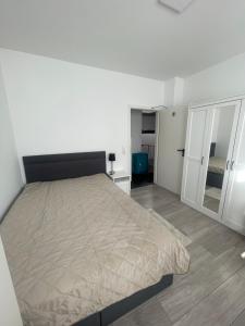 een witte slaapkamer met een bed en een spiegel bij Hostel Kornwestheim in Kornwestheim