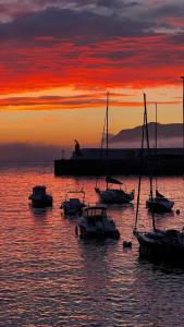a group of boats in the water at sunset at Dxagi-Dxagi in Bermeo