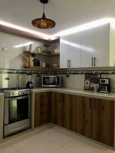 a kitchen with white cabinets and a stove top oven at Comfort Modern Spacious Queenbed in Trujillo