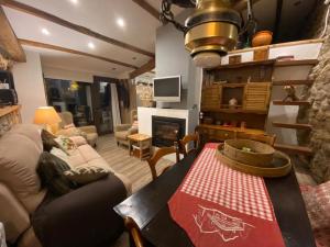 sala de estar con sofá, mesa y chimenea en Idílico refugio de montaña ideal escapadas, en Olopte