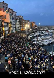 a large crowd of people standing around a marina at Dxagi-Dxagi in Bermeo