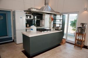 a kitchen with a stove and a refrigerator at The Lookout - Thesen Islands in Knysna