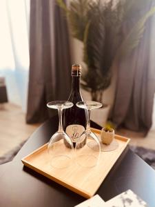a pair of wine glasses sitting on a wooden tray at Apartment Vitale in Bologna