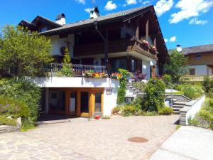 um edifício com uma varanda e flores sobre ele em B&B Casa Bazzanella em Cavalese