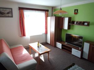 a living room with a couch and a table and a television at Rodinný dům Na Smetance in Vrchlabí