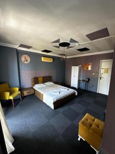een slaapkamer met een groot bed en gele stoelen bij Retro Suites in Istanbul