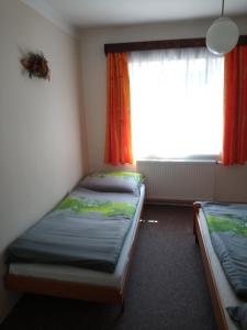 Duas camas num pequeno quarto com uma janela em Rodinný dům Na Smetance em Vrchlabí