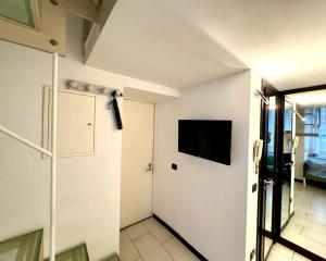 Zimmer mit einer Tür und einem TV an der Wand in der Unterkunft Casetta San Martino in Neapel