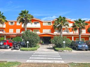 um edifício laranja com palmeiras num parque de estacionamento em Isla de Sal em Santa Maria