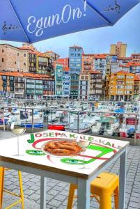 a table with a pizza on top of a marina at Dxagi-Dxagi in Bermeo