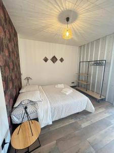a bedroom with a bed and a table and a lamp at Alaimo et Les2Roses in Paray-le-Monial