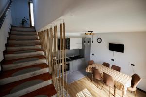 ボルシャにあるComfy Houseのテーブルと椅子、階段が備わる客室です。