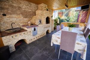 a outdoor kitchen with a stone oven and a table at Comfy House in Borşa
