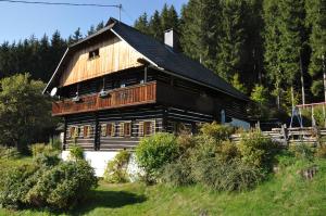 a large wooden house on a hill with trees at Altes Bauernhaus in Gnesau