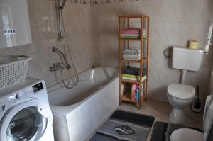 a bathroom with a tub and a toilet and a washing machine at Altes Bauernhaus in Gnesau