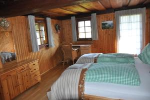 a bedroom with a bed and a desk and windows at Altes Bauernhaus in Gnesau