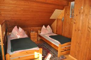 a room with two beds in a wooden cabin at Villa Waldfriede in Gnesau