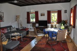 a living room with a couch and a table and chairs at Villa Waldfriede in Gnesau