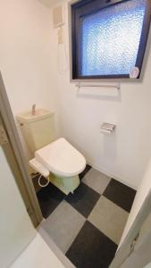 a small bathroom with a toilet and a window at Esperanza 204号室 in Tokyo