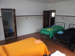 a room with two beds and a green blanket at Albergue Constantino AL in Paredes de Coura