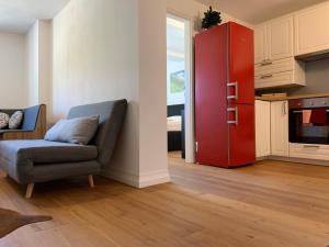 ein Wohnzimmer mit einem Sofa und einem roten Kühlschrank in der Unterkunft Mountain Apartment in Alterzoll