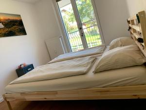 Bett in einem Zimmer mit einem großen Fenster in der Unterkunft Mountain Apartment in Alterzoll