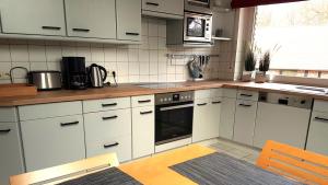 a kitchen with white cabinets and a stove top oven at Große Ferienwohnung, auf Bauernhof mit Ponys und Pferden, ländlich und ruhig, Nähe Dümmer See in Holdorf
