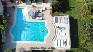 an overhead view of a swimming pool with chairs and an umbrella at Casa T with amazing views in Corfu in Kontokali