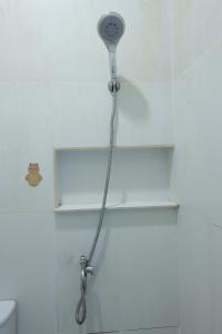 een douchekop in een badkamer naast een toilet bij OYO 93131 Mamapapahouse in Batam Center