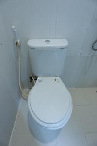 een badkamer met een wit toilet in een kamer bij OYO 93131 Mamapapahouse in Batam Center