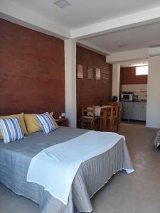 a bedroom with a large bed and a kitchen at Temporario Necochea 1 corrientes in Corrientes