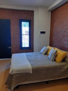 a bedroom with a large bed with yellow pillows at Temporario Necochea 1 corrientes in Corrientes