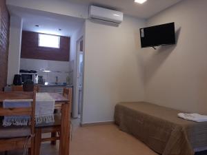 a room with a dining table and a television on the wall at Temporario Necochea 1 corrientes in Corrientes