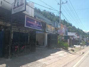OYO 93117 Penginapan Tiga Dara في جايابورا: مبنى على باب من جهة شارع