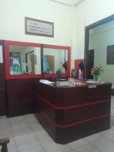 a reception desk with a mirror in a room at OYO 931O12 Tamara Homestay Syariah in Medan