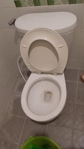 a white toilet with the seat up in a bathroom at OYO 931O12 Tamara Homestay Syariah in Medan