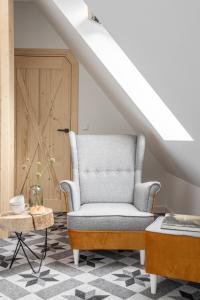 ein Wohnzimmer mit einem Stuhl und einem Tisch in der Unterkunft Apartamenty Pod Stokiem Nosal Zakopane in Zakopane