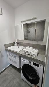 uma casa de banho com uma máquina de lavar roupa e um lavatório em APARTAMENT BUŁGARSKA 60m2-3 POKOJE-PIĘKNY WIDOK-13 PIĘTRO 24H CHECK IN em Poznań