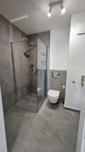 uma casa de banho com uma cabina de duche em vidro e um WC. em APARTAMENT BUŁGARSKA 60m2-3 POKOJE-PIĘKNY WIDOK-13 PIĘTRO 24H CHECK IN em Poznań