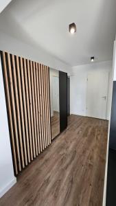 Habitación vacía con paredes blancas y suelo de madera. en APARTAMENT BUŁGARSKA 60m2-3 POKOJE-PIĘKNY WIDOK-13 PIĘTRO 24H CHECK IN en Poznan