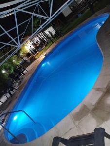 a large blue swimming pool at night at Cabañas Pacari Tampu in Mendoza