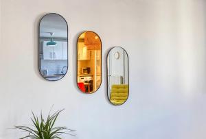 a room with three mirrors on a wall at Le Havre Chic et Spacieux d'Angoulême - Calme & Confort Moderne in Angoulême