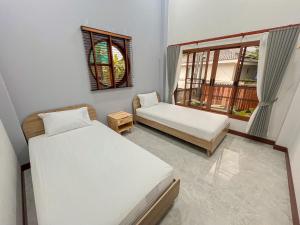 にあるมาเหนือพูลวิลล่า แม่แจ่ม เชียงใหม่ Ma-Nhuer pool villa Mae Chaem Chiangmaiのベッド2台と窓が備わる小さな客室です。