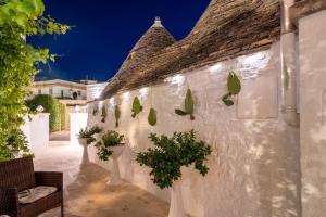 een witte muur met potplanten erop bij La Mandorla Luxury Trullo in Alberobello