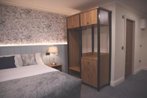 a bedroom with a bed and a wooden cabinet at The Coachmans Inn in Roscommon