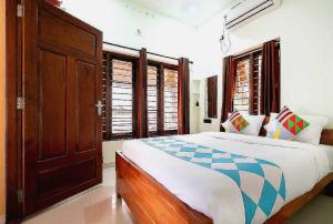 um quarto com uma cama e algumas janelas em Hotel O ATHARVAM RESORT em Cochin