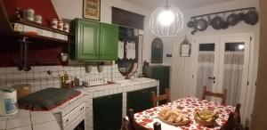 une cuisine avec des armoires vertes et une table avec une table dans l'établissement EliT alle porte del Chianti, à Cavriglia