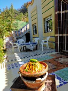 a bowl of food in front of a house at دار الضيافة تازكة Maison d'hôtes Tazekka in Taza